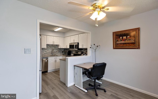 kitchen with stainless steel appliances, a kitchen breakfast bar, kitchen peninsula, and white cabinets