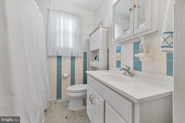 bathroom featuring tile walls, backsplash, vanity, toilet, and tile patterned floors