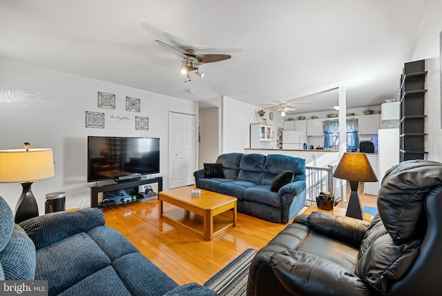 living room with ceiling fan and light hardwood / wood-style flooring