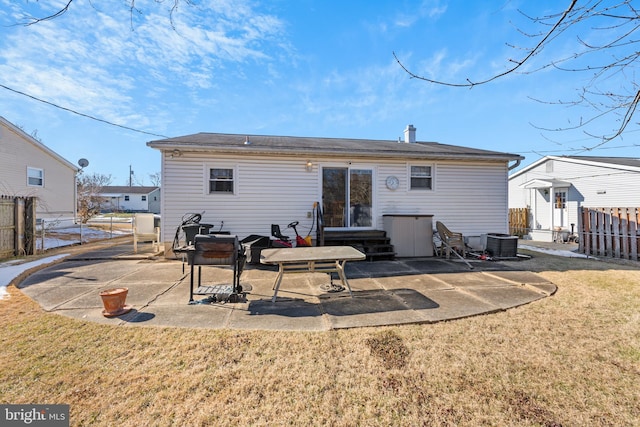 rear view of property featuring a yard, central AC, and a patio area