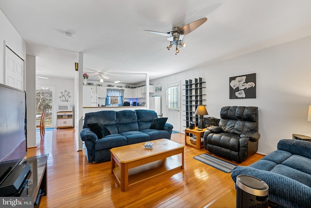 living room featuring light hardwood / wood-style flooring, plenty of natural light, and ceiling fan