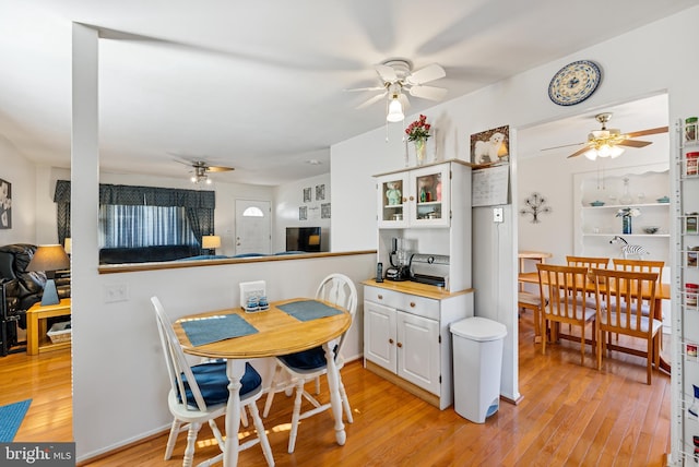 dining area with ceiling fan and light hardwood / wood-style flooring