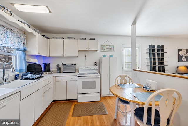 kitchen featuring white cabinetry, white appliances, sink, and light wood-type flooring