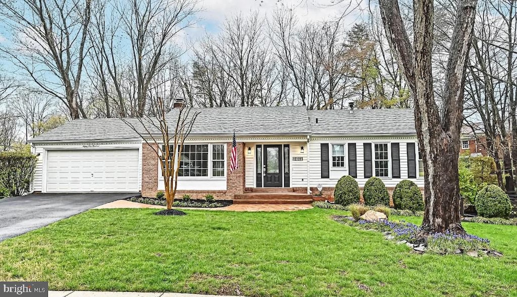 single story home featuring a garage and a front lawn