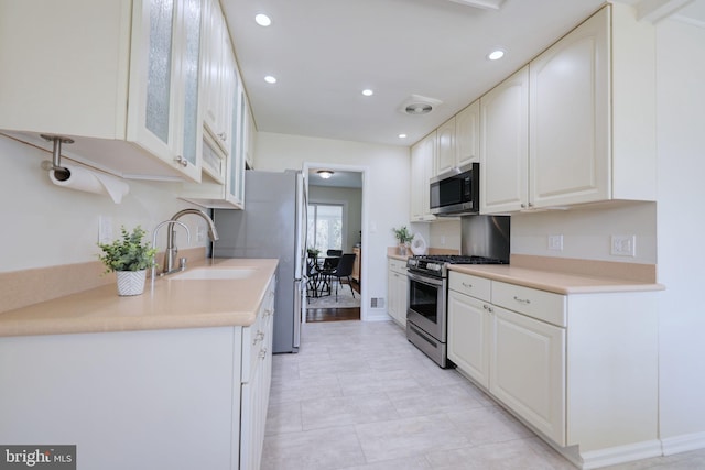 kitchen featuring visible vents, a sink, white cabinetry, recessed lighting, and stainless steel appliances