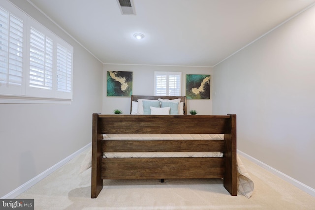 carpeted bedroom with baseboards, visible vents, and ornamental molding