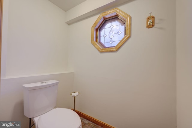 bathroom with toilet and baseboards