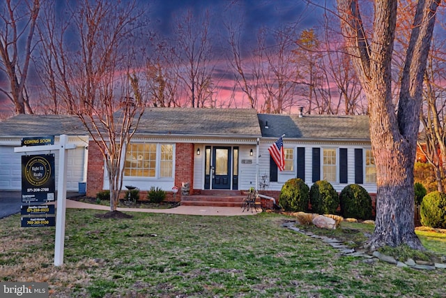 ranch-style home with a yard and brick siding