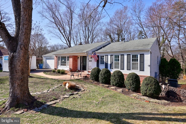 ranch-style house featuring a front lawn, a shingled roof, a garage, brick siding, and a chimney