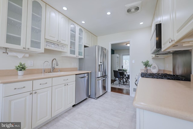 kitchen with visible vents, a sink, light countertops, white cabinets, and appliances with stainless steel finishes