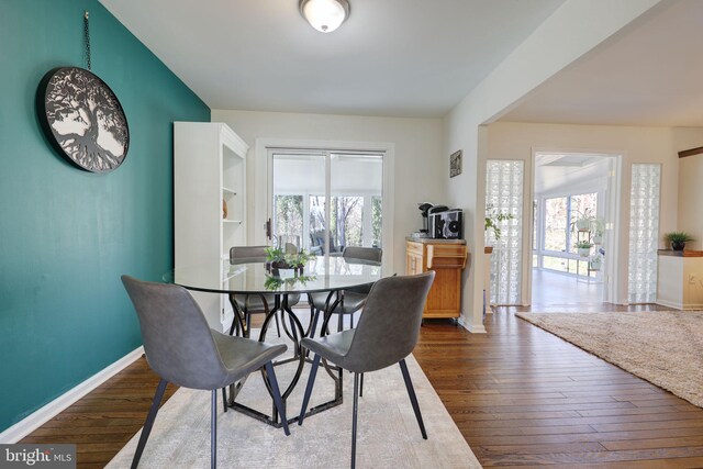 dining area with baseboards and wood-type flooring