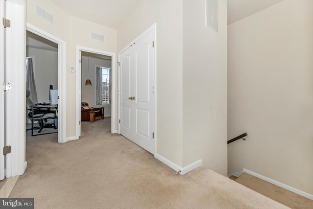 hallway with light colored carpet