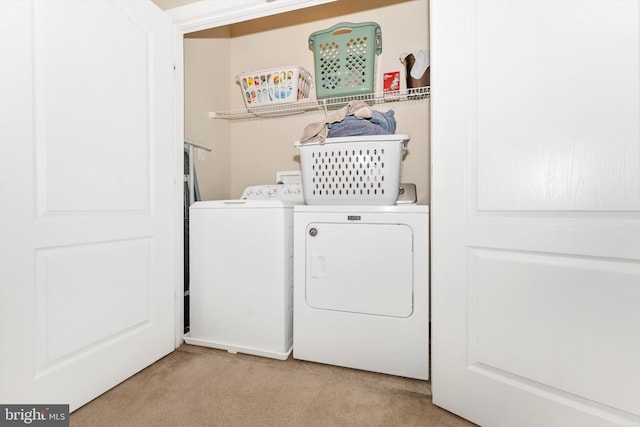 laundry room featuring separate washer and dryer and light carpet