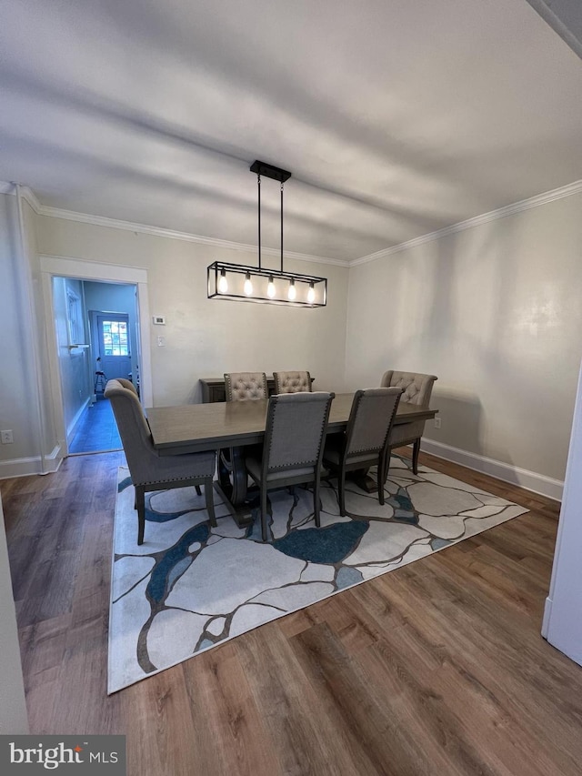 dining room featuring dark hardwood / wood-style flooring and crown molding