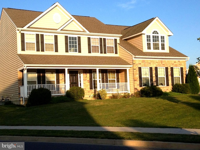 colonial house featuring a front yard and a porch