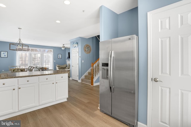 kitchen with light wood-style flooring, white cabinets, open floor plan, hanging light fixtures, and stainless steel fridge with ice dispenser