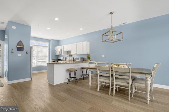 dining area featuring recessed lighting, visible vents, baseboards, light wood finished floors, and an inviting chandelier