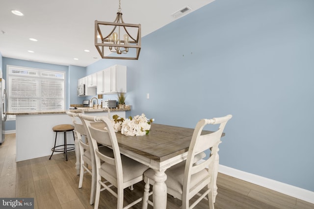 dining space featuring light wood-type flooring, baseboards, visible vents, and recessed lighting