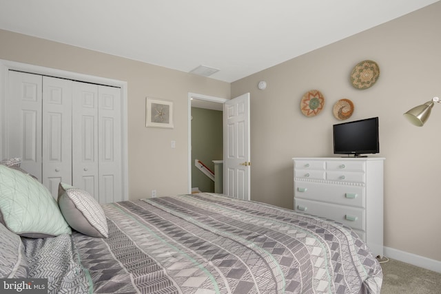 carpeted bedroom featuring baseboards and a closet