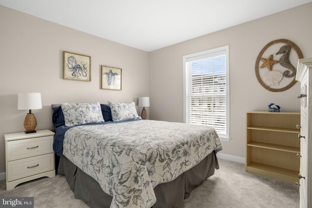 bedroom with light carpet and baseboards