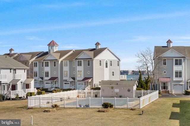 exterior space with a residential view, fence, and a lawn