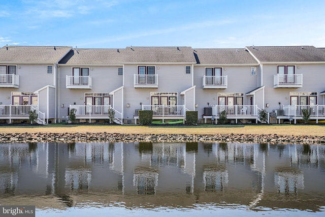 rear view of house featuring a water view and a residential view