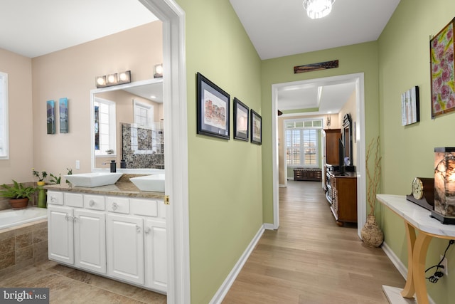 corridor with sink and light hardwood / wood-style flooring