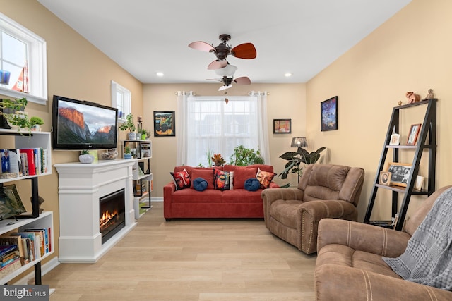 living room featuring ceiling fan and light hardwood / wood-style floors