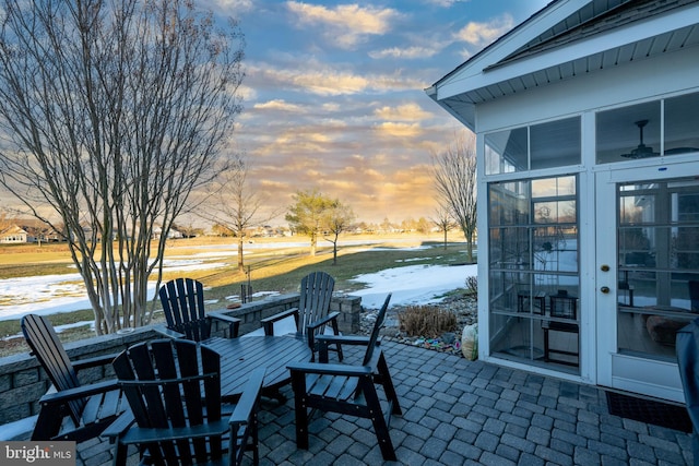 patio terrace at dusk featuring french doors and a sunroom