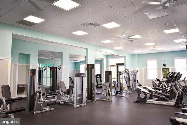 gym with ceiling fan and a paneled ceiling