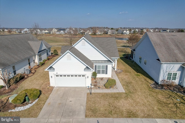 view of front of house featuring cooling unit, a garage, and a front lawn