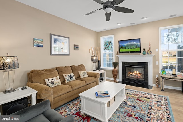 living room featuring a wealth of natural light, ceiling fan, and light hardwood / wood-style flooring