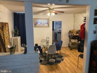 dining area featuring wood-type flooring and ceiling fan