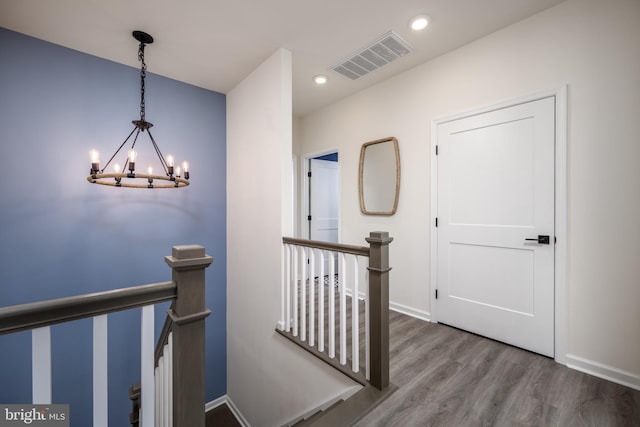 corridor featuring a notable chandelier and hardwood / wood-style flooring