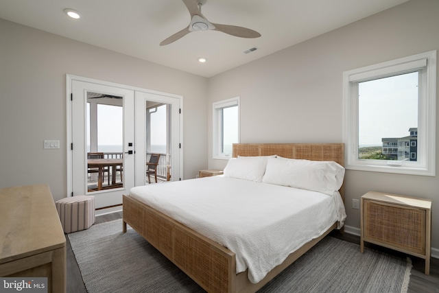 bedroom featuring multiple windows, dark hardwood / wood-style floors, access to exterior, and french doors