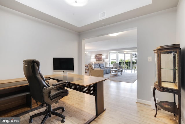 home office with light hardwood / wood-style floors