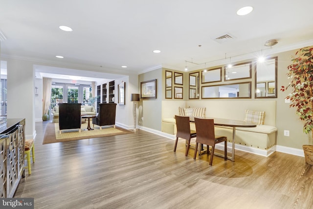 dining room featuring french doors, ornamental molding, and light hardwood / wood-style floors