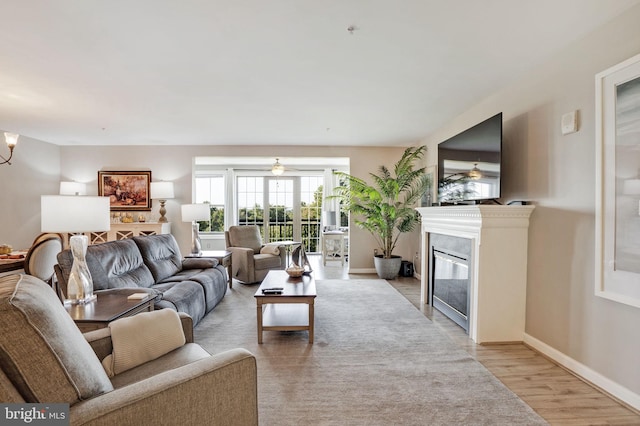 living room with an inviting chandelier and light hardwood / wood-style flooring