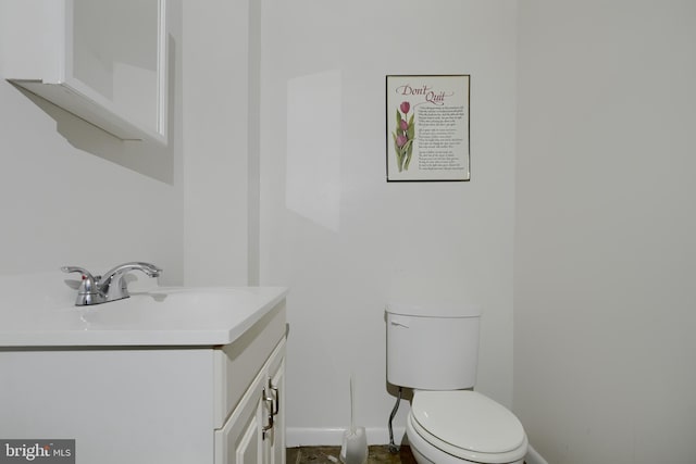 bathroom featuring toilet, baseboards, and vanity