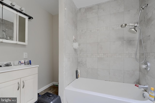 bathroom featuring bathtub / shower combination, baseboards, and vanity