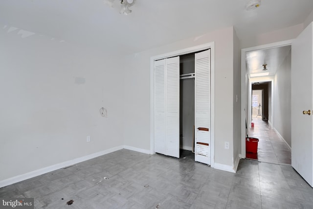 unfurnished bedroom with a closet and baseboards