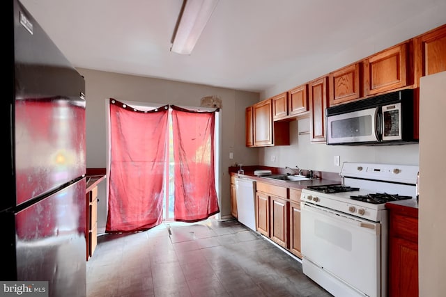 kitchen with stainless steel appliances, brown cabinets, and a sink