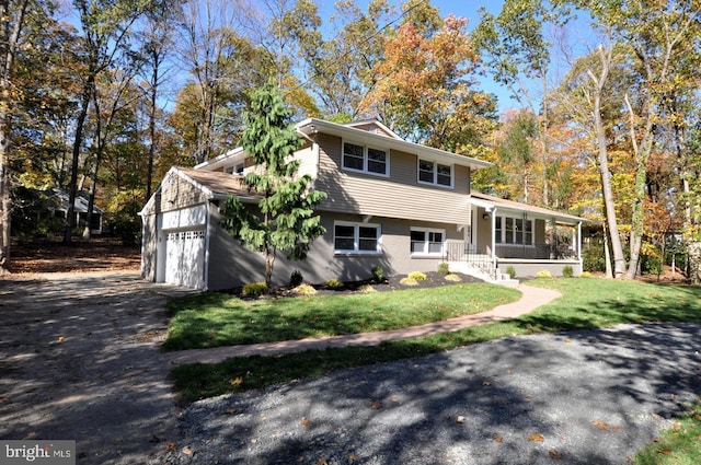 split level home featuring a porch, a garage, and a front yard