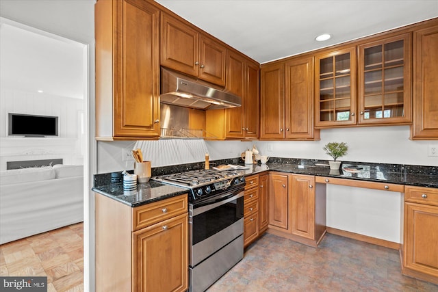 kitchen featuring dark stone counters and stainless steel gas stove