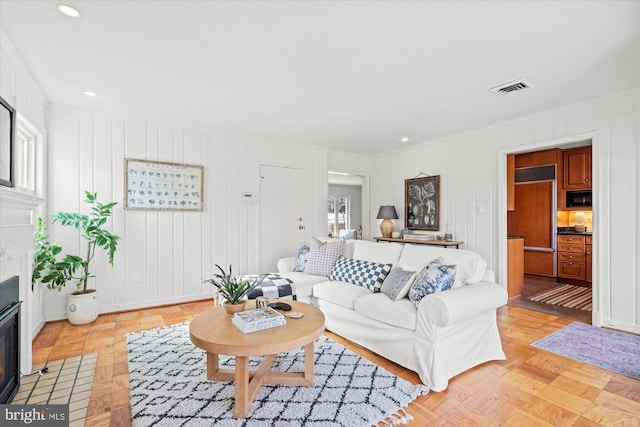 living room with crown molding and light parquet flooring