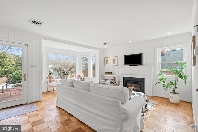 living room featuring a brick fireplace and light parquet floors