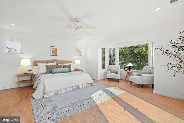 bedroom featuring ceiling fan, ornamental molding, and light hardwood / wood-style floors