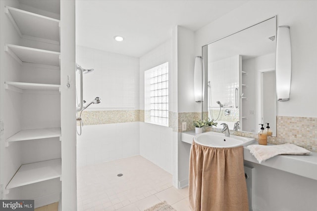 bathroom with tile patterned flooring, sink, tile walls, and tiled shower