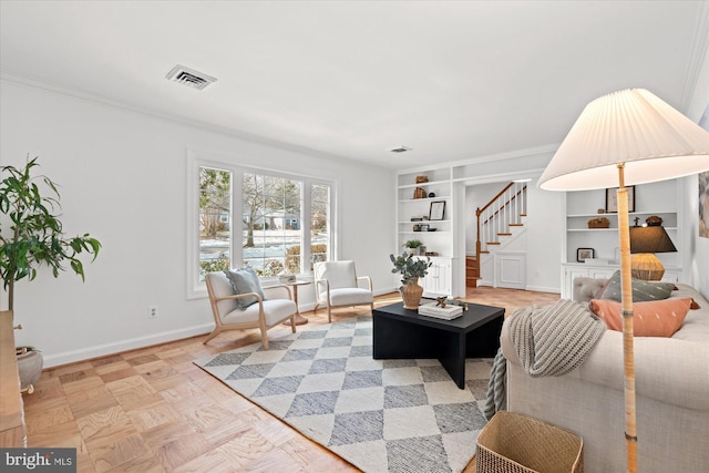 living room featuring crown molding, light parquet floors, and built in shelves