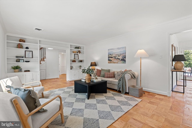 living room featuring built in shelves, ornamental molding, and light parquet flooring